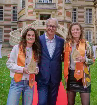 Un homme et deux femmes qui posent avec un trophée devant la mairie de Versailles