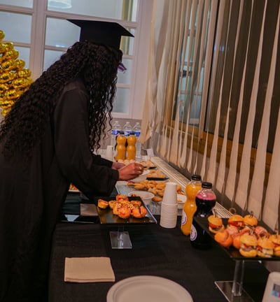 Une diplômée qui se sert de la nourriture au buffet