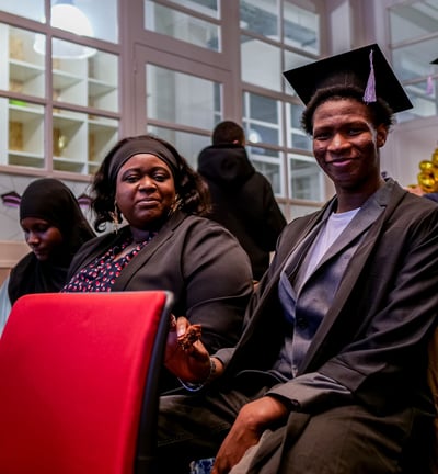 Un étudiant et sa mère sourient pendant la remise de diplômes