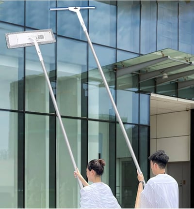 a man and woman cleaning a glass door