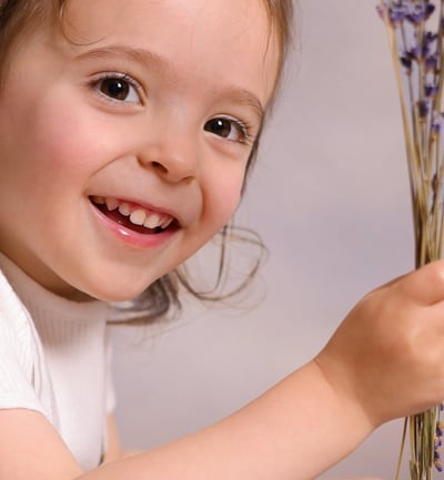 a young boy holding a bunch of lavender flowers