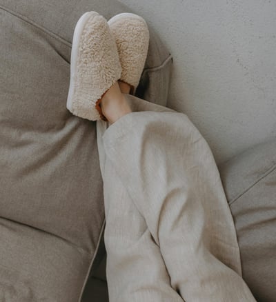 woman lying in pajamas and house shoes