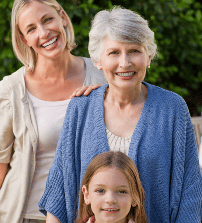 a young girl, a woman and her mother (grandmother) standing in front of a table