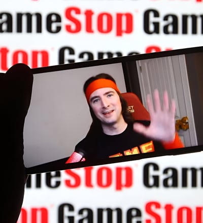 a person holding a cell phone in front of a wall with a sign that says
