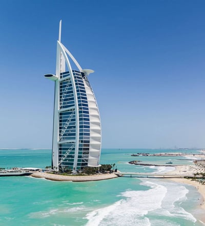 Dubai skyline with Burj Al Arab by the turquoise sea.