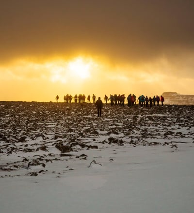 a group of people standing on a snowy field in the Faroe Islands