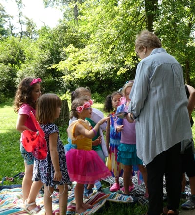 A volunteer helping children with crafts at an event in Crescent Hills Park