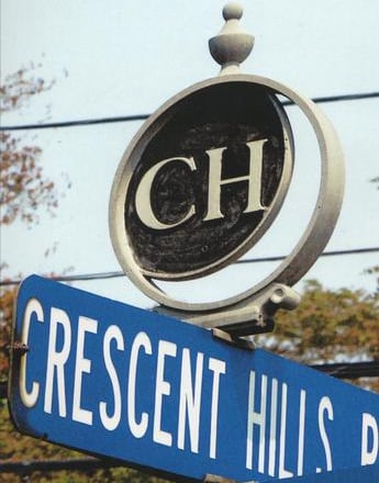 A Street sign of Crescent Hills Rd showing a logo mounted on top with the letters C H