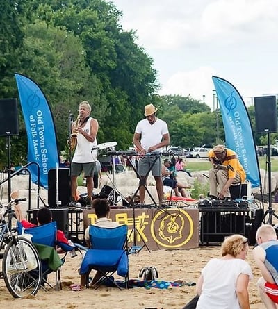 Musical performance on the beach in Chicago with saxaphonist, guitarist and DJ