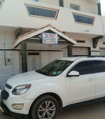 a white suv parked in front of a building