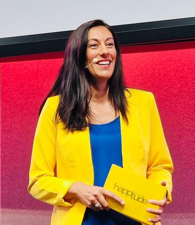Aurelie Litynski speaking on stage about positive workplace culture