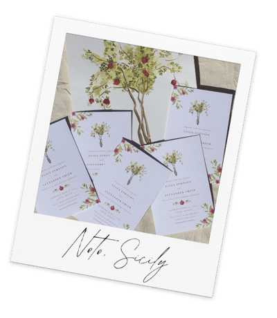 a bunch of wedding invitations with a pomegranate tree in the background