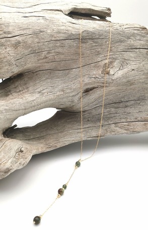 Sautoir de style chapelet, posé sur un tron de bois flotté