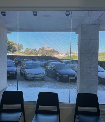 a row of chairs in a room with a view of a parking lot