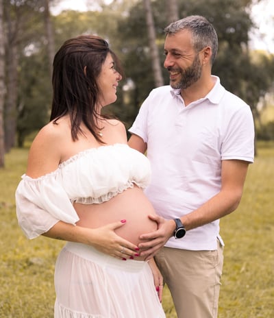 Sessió de fotos d'embaràs d'una parella amb dona embarassada en entorn natural exterior