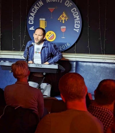 Alex Duffy doing stand-up comedy with keyboard in Tadcaster
