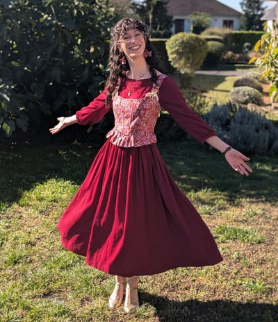 Aude Fy en robe rouge et corset folklorique