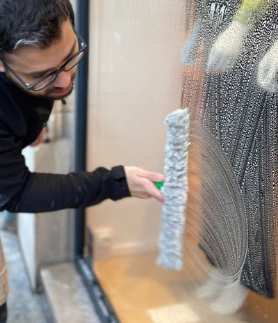 Technicien de M & M Services Pro nettoyant la vitrine du magasin Léo et Ugo à Rouen