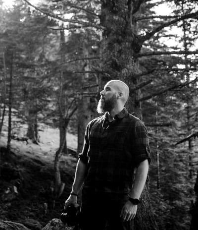 Homme debout dans une forêt.