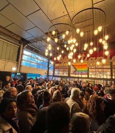 une foule de personnes debout dans une grande pièce