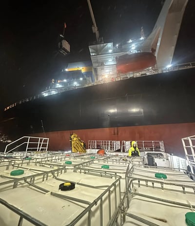 a large ship in the water with a man standing on the deck