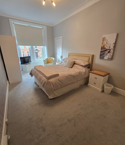 a second bedroom with a bed and a chair