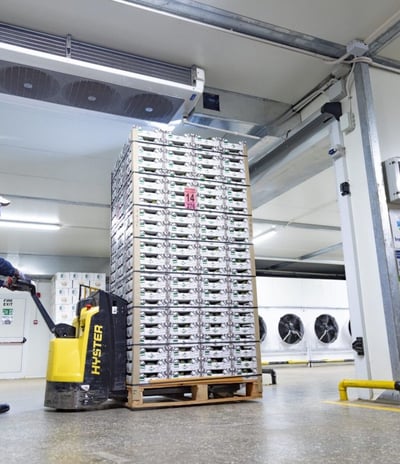 a man in a blue jumpsuit and a yellow helmet installing precoolers