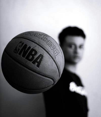 a man holding a basketball ball in front of a wall
