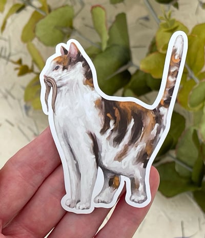 a sticker of a cat with a moustache sitting on a person's hand