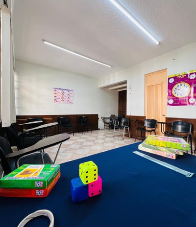 a classroom with a table and chairs and a clock