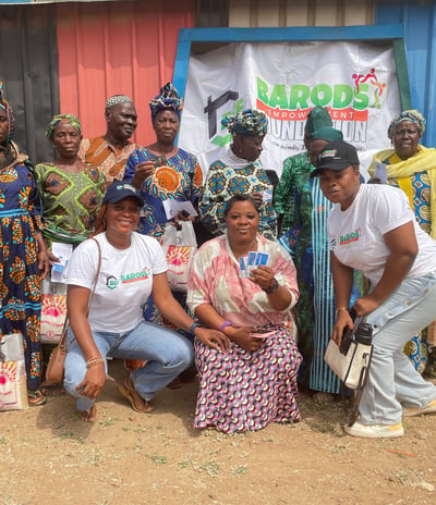 a group of people standing around a woman holding a baby