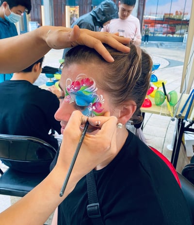 Caroline Face Painting a Flower Eye Design