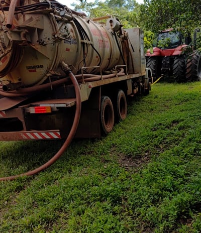 a truck with a large tank sitting on the grass
