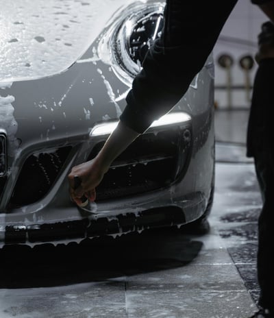 Un homme nettoie une voiture sportive avec une éponge à Toulouse