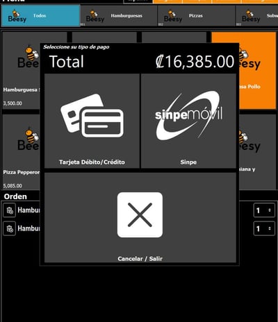 a man in a blue shirt is sitting at a desk with a laptop and a