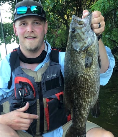 a man holding a fish on a boat
