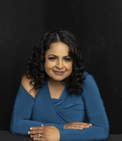 A woman sitting with crossed arms and a smile