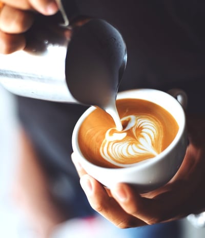 Barista preparing a fresh latte at a wedding or corporate event with Ancestral on Wheels mobilecoffe