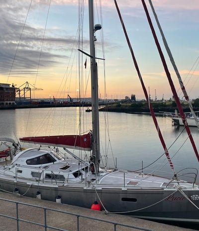 a sailboat docked at a dock with a sunset