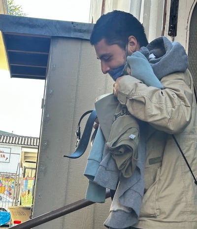 Man smiling through a face mask getting clothes