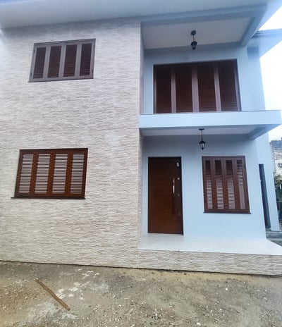 a house with a white brick wall and a brown door