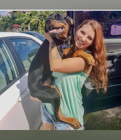 a woman holding a dog in her arms