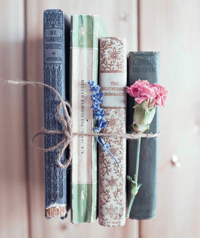 stack of ancient books with flowers - symbolizing learning & growth