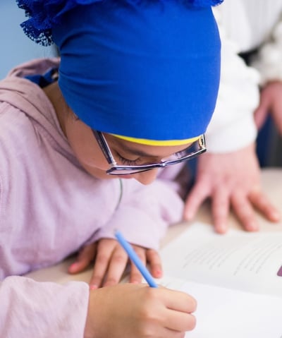 Elementray girl uses a workbook to share her thoughts.