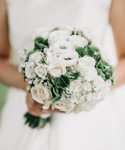 a bridesmael holding a bouquet of white roses