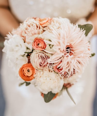 a bridesmael holding a bouquet of flowers