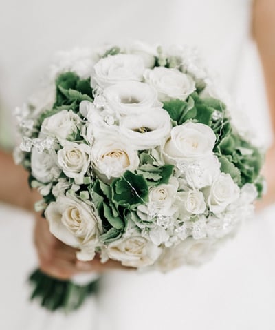 a bridesmael holding a bouquet of white roses