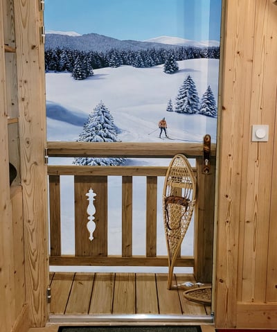 Une porte d'entrée basique se transforme en décor hivernal jurassien. Ce décor habille une porte de service disgracieuse.