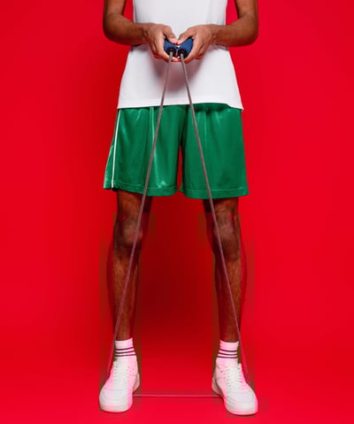 a man in a white tank top and green shorts