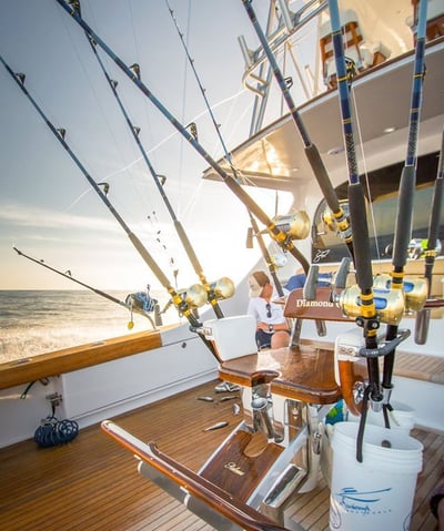 a man fishing on a boat with fishing rods